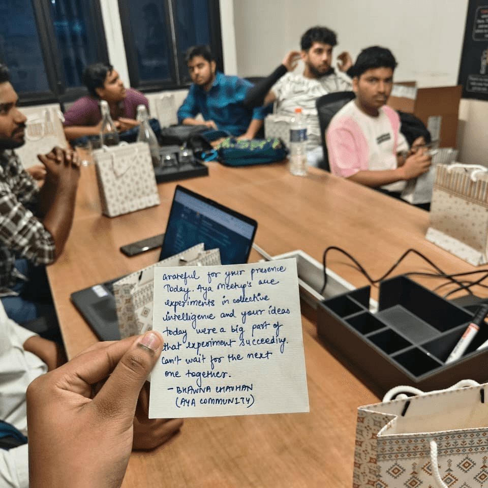 Handwritten thank-you note held in front of attendees at an Aya community meetup in Delhi