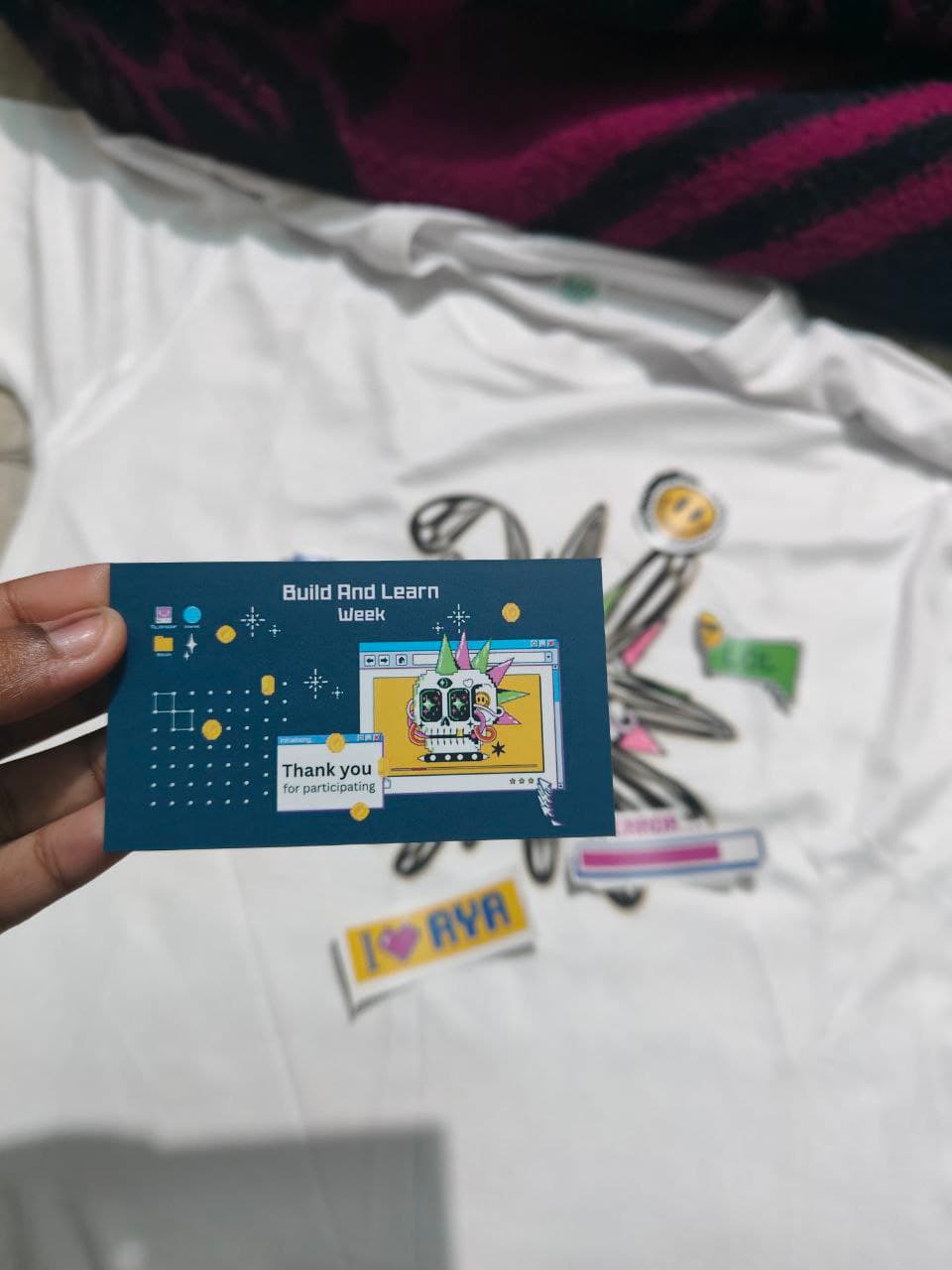 Build and Learn Week participation card, stickers, and an Aya community T-shirt
