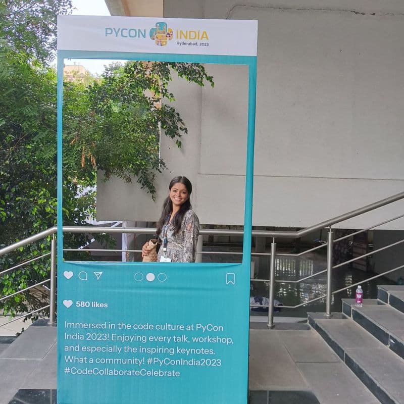 Bhawna standing inside a PyCon India 2023 photo frame
